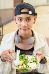 Non binary gay man eating salad