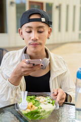 Non binary gay man eating salad