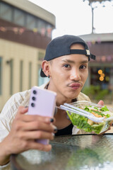 Non binary gay man eating salad