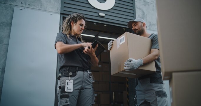 Multiethnic Workers Taking Cardboard Boxes with Online Orders, E-Commerce Goods to Logistics Retail Warehouse. Female Inventory Manager Scanning Parcels with Barcode Scanner, Using Tablet Computer.