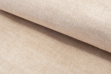 A twisted piece of light fabric. A roll of white fabric. Textile. Folds.