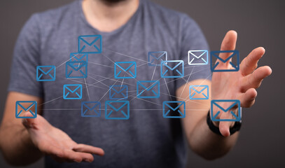 Stock photo of a person managing and interacting with a network of email icons, representing...