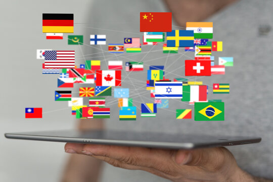 Image of a tablet displaying interconnected flags of various countries, symbolizing global communication and networking. - Powered by Adobe
