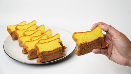 Slices of Lapis Surabaya, a traditional Indonesian layer cake, neatly arranged on a white plate. This rich and buttery cake features soft yellow and chocolate layers.