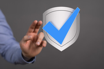 Hand reaching for a digital shield with a checkmark, symbolizing data security and approval.