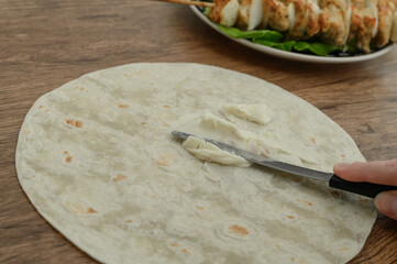 Spread the melted cheese over the round tortilla