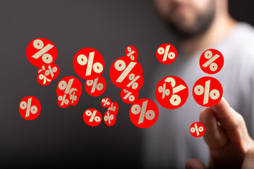 Image of red percentage symbols hovering near a man's hand, ideal for discount, sale, or finance...