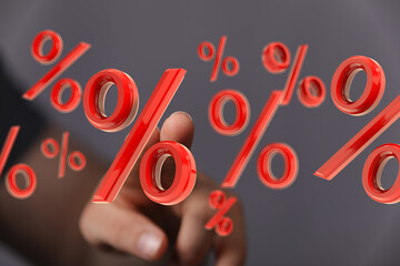 Image of a hand interacting with 3D percentage symbols, ideal for finance, banking, and interest...