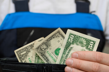 a man holds a fan of US dollars in his hand