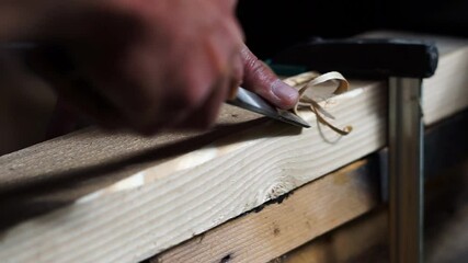 Carpenter working with a sharp chisel in a small woodworking shop. - Powered by Adobe