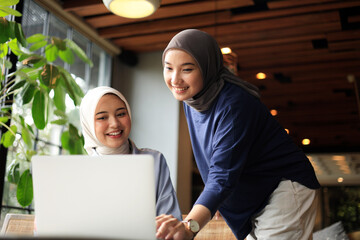 Two Muslim Friends Wearing Hijab Working on Laptop at Coffee Shop