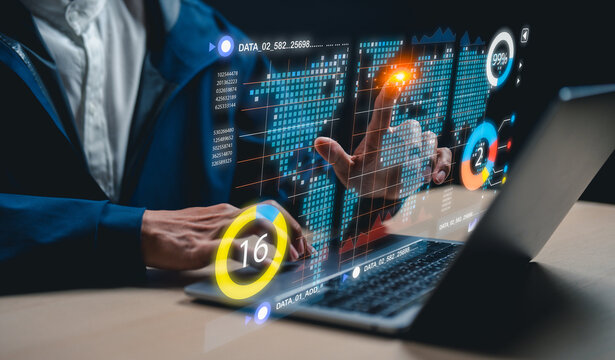 A person interacts with futuristic digital data visualizations and graphs projected above a laptop, representing data analysis and technology innovation.