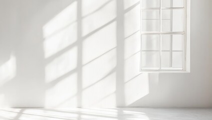Obraz premium Sunlight streams through a large window, casting dramatic shadows on a white room