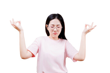A young woman with glasses and a pink shirt is meditating with her eyes closed and hands in a mudra...
