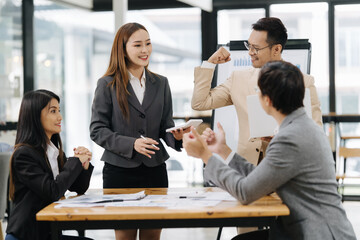 Collaborative Harmony: Capturing a dynamic team's collaboration as they gather around a table in a brightly lit conference room, fostering an environment of creativity and synergy.