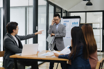 Conflict and Decisions in Boardroom: The photo captures a tense moment in a modern office, with a...