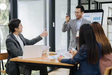 Business Presentation Success: An enthusiastic business team collaborates during a dynamic...