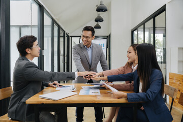 United Vision: Colleagues join hands around a conference table, in a photorealistic visual of team...