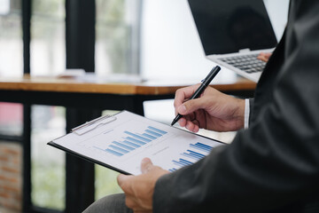 Financial Analysis in progress: An executive meticulously reviews financial data with pen in hand,...