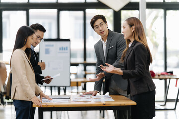 Strategic Minds at Work: Four business professionals, engaged in a focused discussion around a...