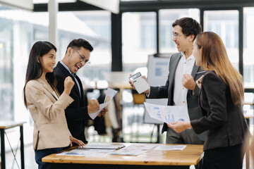 Celebration of teamwork at workplace: A group of professionals share an energetic moment of...