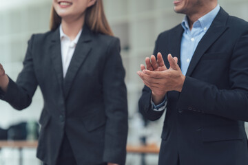 Business Applause: Two professionals, impeccably dressed in tailored business suits, stand...