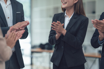 Applauding Business Team: A close-up shot showcasing a group of business professionals warmly...