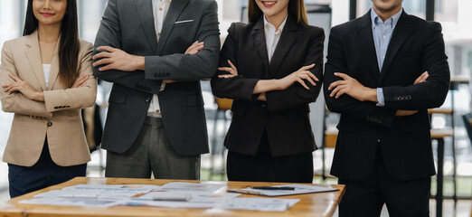 Confident Professionals: A group of business professionals, exuding confidence, stand shoulder-to-shoulder, arms crossed, ready to take on any challenge