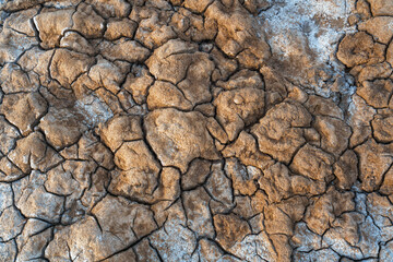 Textured background  of frozen soil, clay, ice, and snow on the salt lake of Baskunchak in Russia, viewed from above.