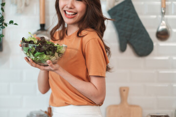 Young Asian woman is preparing a fresh healthy vegan salad with many vegetables in the kitchen, Dieting Concept. Healthy food Lifestyle. Cooking At Home.