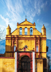 Old yellow colonial church in San Cristobal de las Casas with beautiful blue sky in Chiapas, Mexico