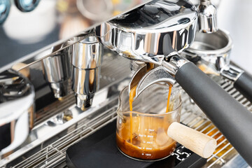 Coffee machine brewing espresso in to glass cup.Barista while preparing and working with coffee...