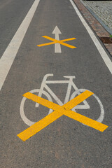 Urban street marking highlights bike lane restrictions in a bustling city on a sunny afternoon