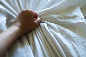 Woman's hand grabbing a sheet
