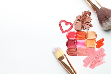 Different cosmetic products and makeup brushes on white background, flat lay. Space for text