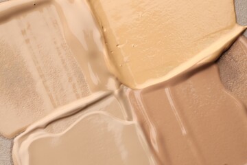 Colorful skin foundations as background, top view