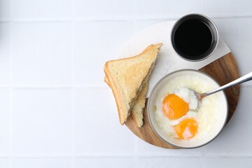 Traditional asian breakfast with half-boiled eggs in bowl, soy sauce and toasted bread on white...