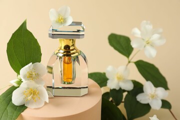 Bottle of perfume and jasmine flowers on beige background, closeup