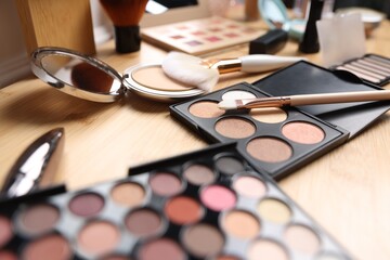 Different makeup products on wooden vanity, closeup