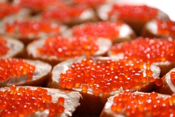 Buffet menu. Sandwiches with red caviar on table, closeup