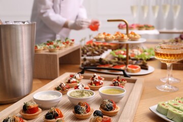 Chef arranging appetizers on buffet table, selective focus