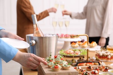 People with different appetizers at buffet, selective focus