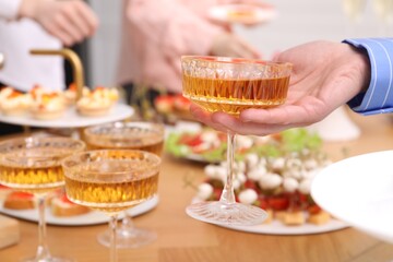 Buffet menu. Woman taking glass of sparkling wine from table, closeup