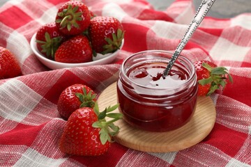 Tasty homemade strawberry jam and berries on table, closeup
