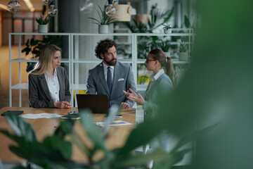 Business team discussing strategy in modern green office