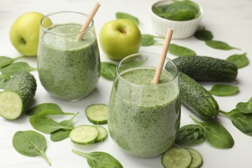 Tasty spinach smoothie and ingredients on white table, closeup