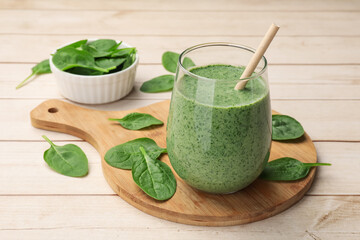 Tasty smoothie and spinach leaves on white wooden