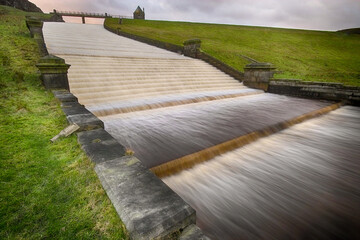 Long exposure of water flowing down the stepped spillway at Butterley Reservoir, West Yorkshire,...