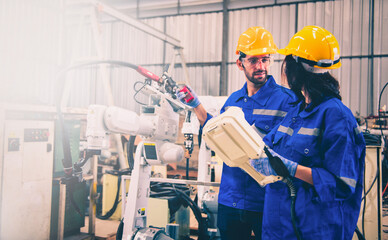 Engineers mechanic using computer controller Robotic arm for welding steel in steel factory...