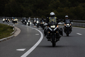 Bikers riding on scenic highway at dusk